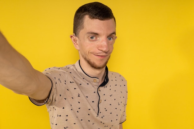 Man on yellow background taking selfies