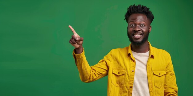 Man in yellow jacket points to camera with smile on his face