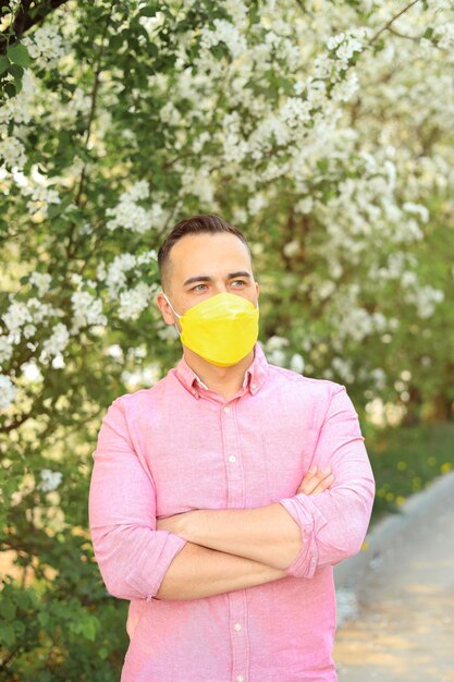 Man in yellow medical mask in the park