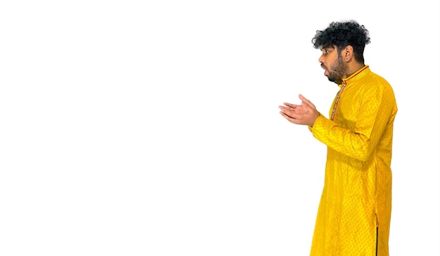 A man in a yellow outfit is praying.