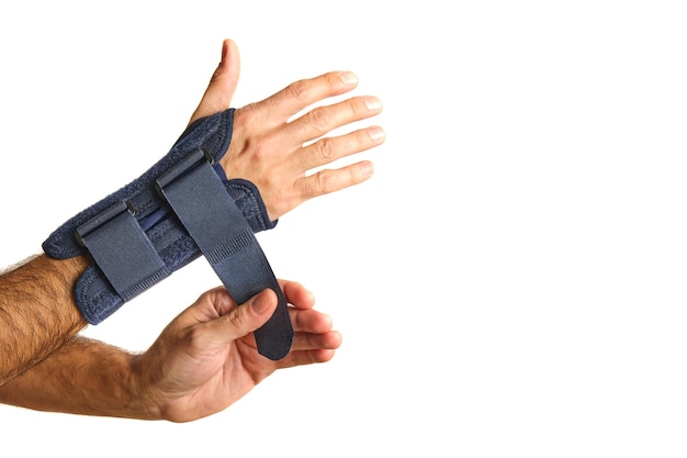 Man39s hands putting on a therapeutic wrist brace to relieve the pain of a sprain