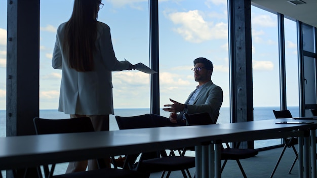 Manager showing contract papers to company executive Thinking businessman rest