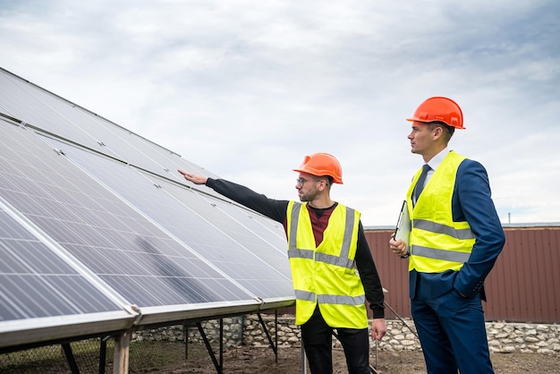 The manager in special clothes talks to the worker in special clothes at the expense of installation of economic panels Green electricity concept