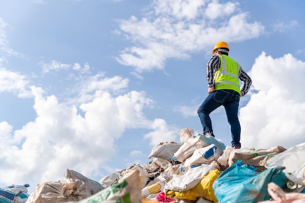 A manager stands holding a tablet on top of the recycling bin at recycling plant Recycle waste Recycle waste business concept