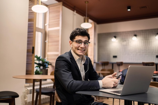 The manager uses an office laptop in a business suit smiles and thinks about the project