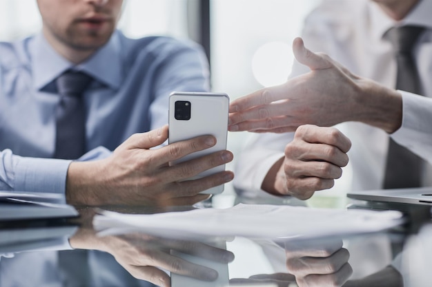 managers read text message on mobile phone in office