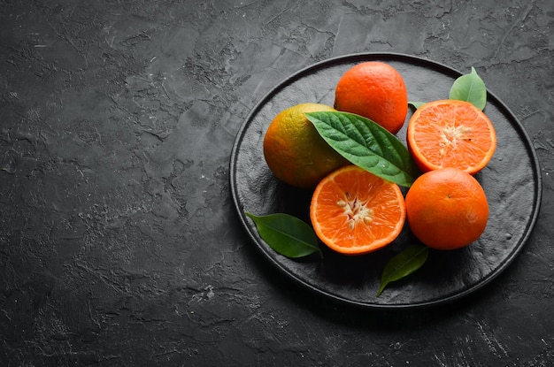 Mandarin on a black stone background Citrus fruits Top view Free space for your text