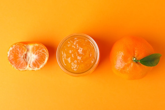 Mandarin jam and ingredients on orange background