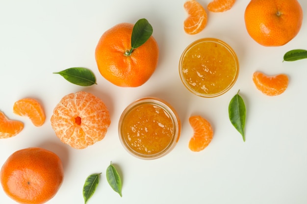 Mandarin jam and ingredients on white background, top view