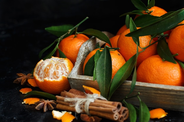 Mandarins and spices on a dark background close up