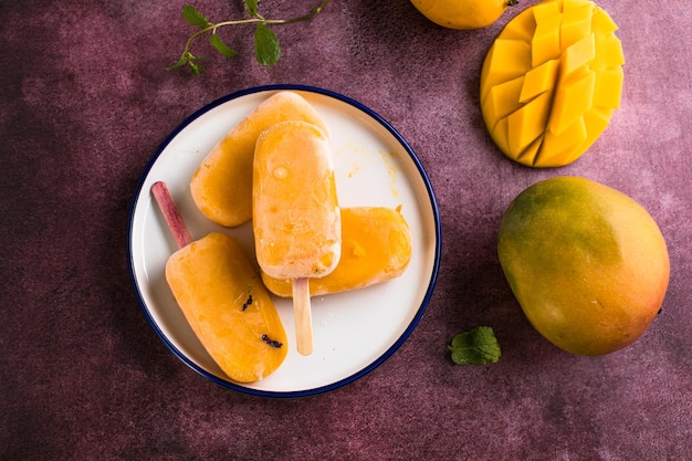 Mango banana popsicles with fresh fruits flat lay top view