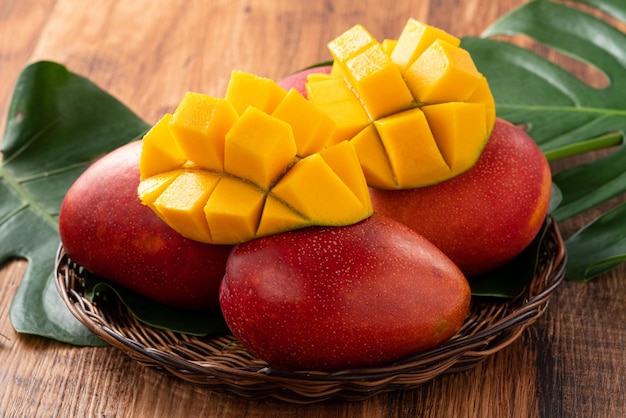 Mango Fresh mango fruit with leaves over dark wooden table background