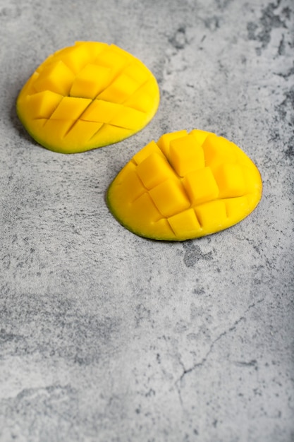 Mango fruit cube slices placed on stone background. 