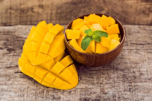 Mango fruit and mango cubes on the wooden table