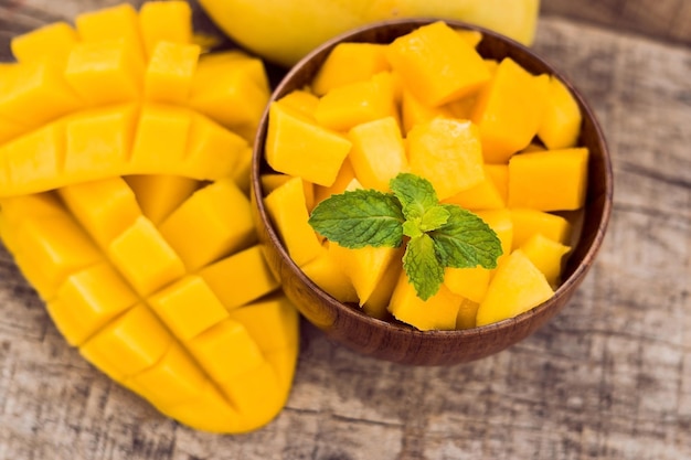 Mango fruit and mango cubes on the wooden table