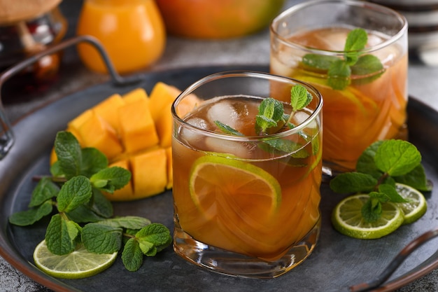 Mango iced tea with lime and mint. Refreshing organic soft drink