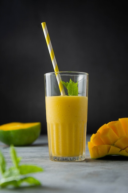 Mango juice in glass with fresh mango sliced fruit and mint leaves