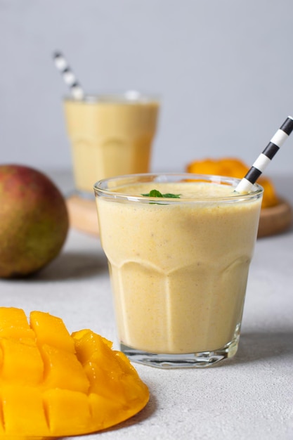 Mango lassi in glasses on gray background Freshness indian lassi made of yogurt water spices mango