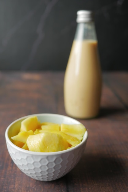 mango smoothie and fresh mango on table