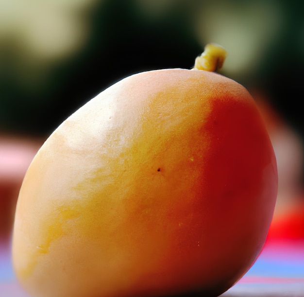 A mango that is on a table with a red background.