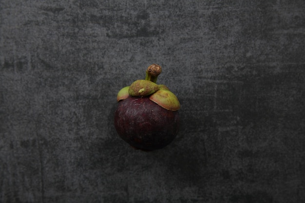 Photo mangosteen fruit on dark rock background