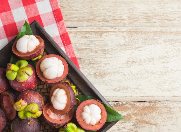 Photo mangosteen fruit on wooden background, top view