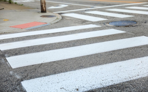 A manhole cover in the street is painted on the sidewalk.