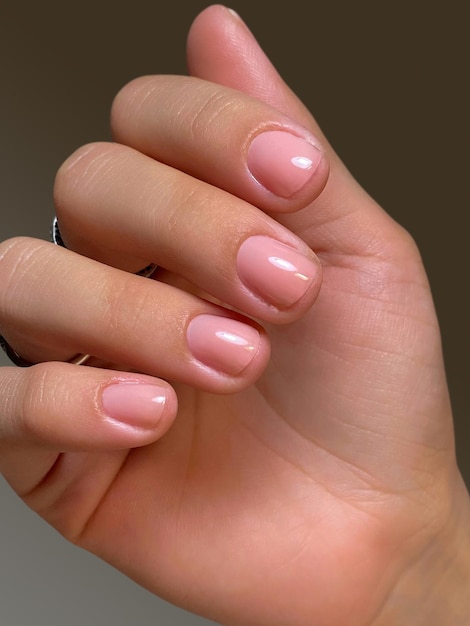 Manicure nude style Women hand with beautiful manicure Spa skin care beauty treatments beauty salon