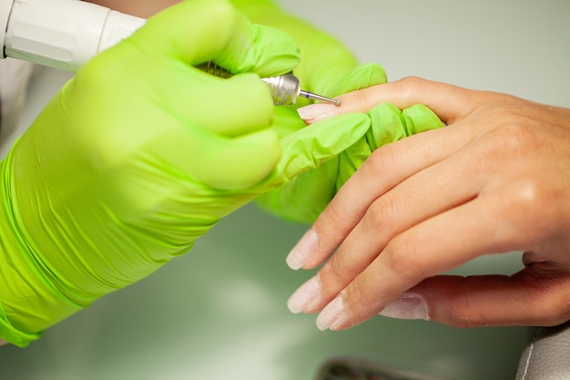 Photo manicure in process. woman in a nail salon receiving a manicure by a beautician