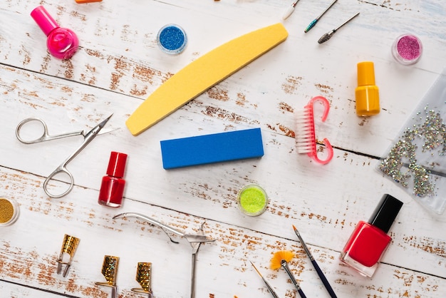 Manicure set and nail polishes on a white wooden 