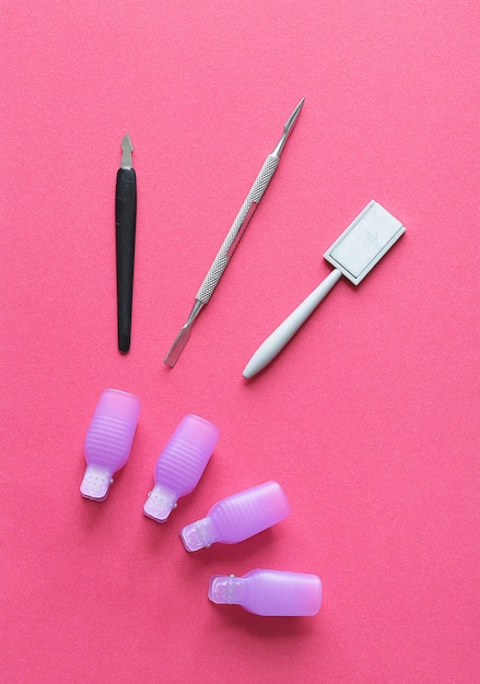 Manicure set for shellac with cotton swabs on a pink background close up