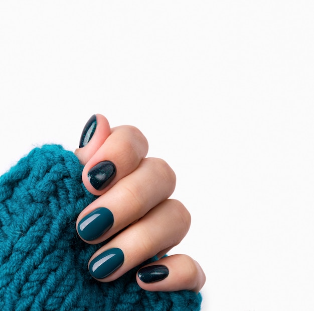 Manicured woman's hand in warm wool turquoise sweater