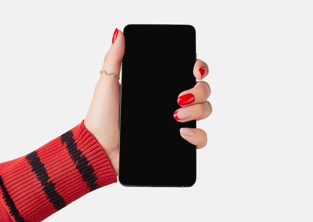 Manicured womans hand holding smartphone with blank screen