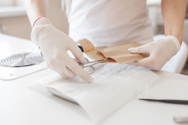 Manicurist cleaning her place to service a new client. Sterilizing salon table to prevent infection.