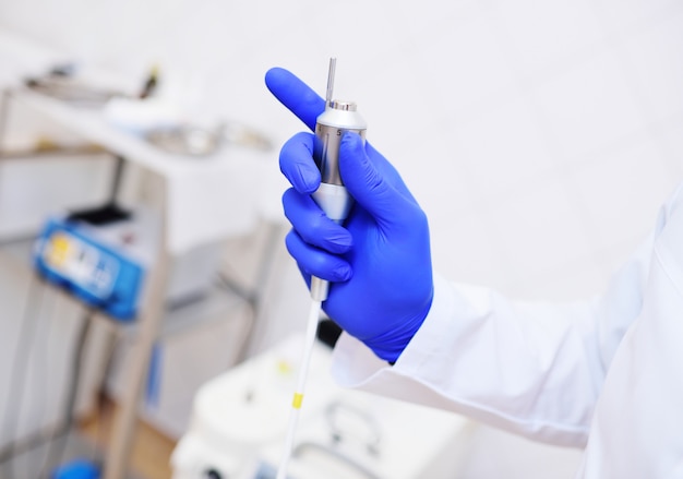 Manipula or neodymium laser nozzle close-up in the hands of the doctor.