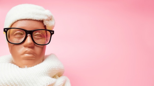 Mannequin with glasses and a scarf, discounts on winter clothes and accessories, on a pink background