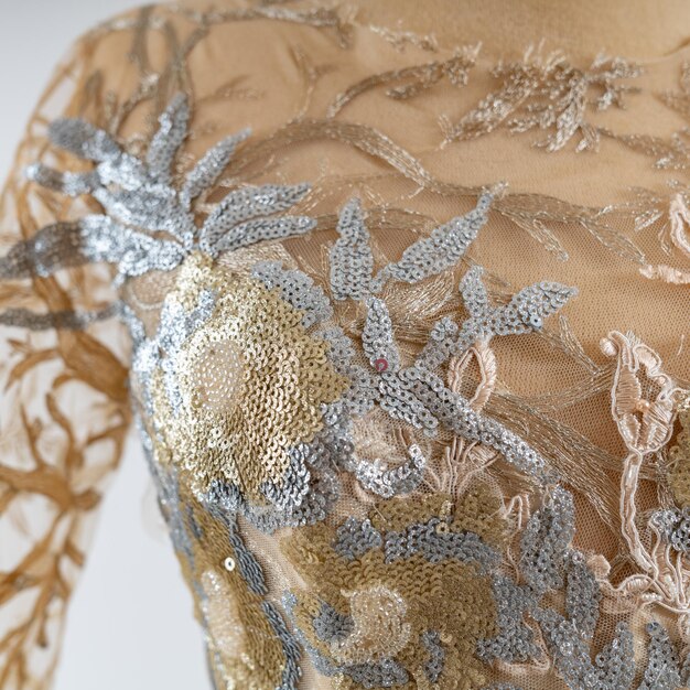 Photo a mannequin with gold sequins and lace on the sleeve