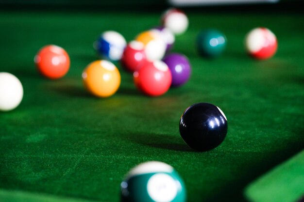 Photo mans hand and cue arm playing snooker game or preparing aiming to shoot pool balls on a green billiard table colorful snooker balls on green frieze