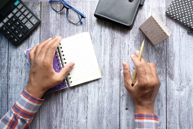 Mans hand turning a pager of a diary and analyzing calendar date