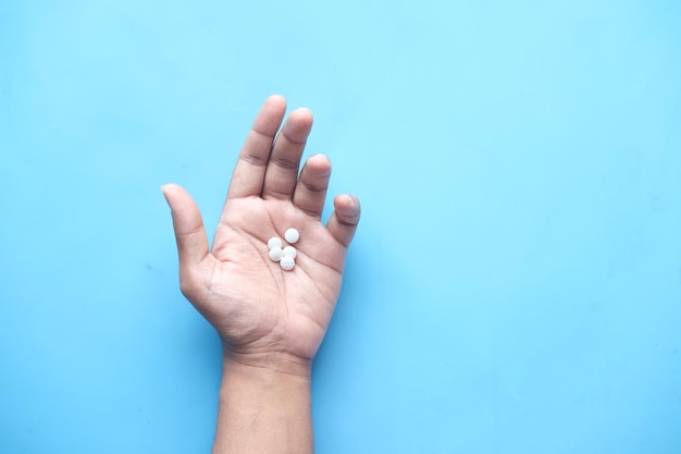 Mans hand with medicine spilled out of the pill container