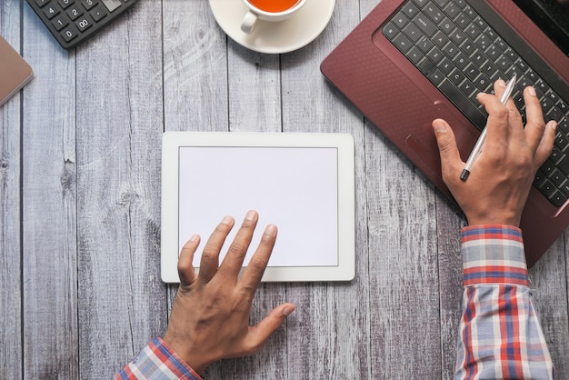 mans hand working on digital tablet on office desk