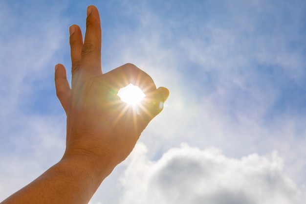 Mans hands holding sun rays