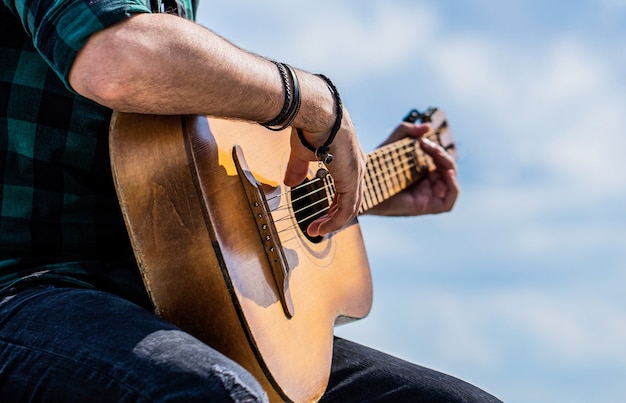 Mans hands playing acoustic guitar, close up. Acoustic guitars playing