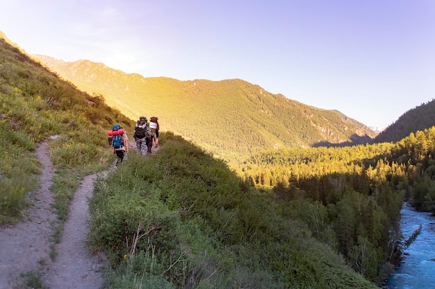 Mans hiking at sunset mountains with heavy backpack Travel Lifestyle wanderlust adventure concept summer vacations outdoor alone into the wild