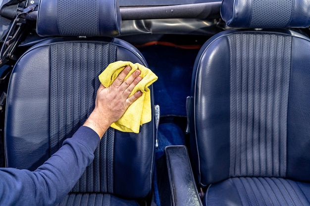 Manual cleaning of the leather in the interior of the car with a micro towel