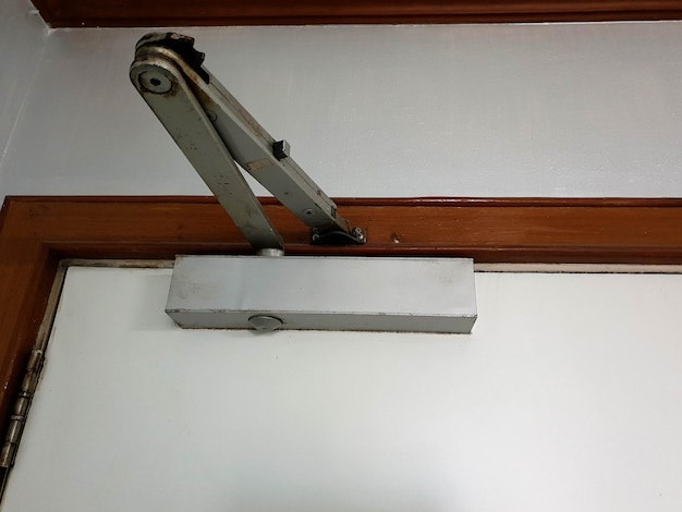 A manual door closer stores the energy used in the opening of the door in a compression