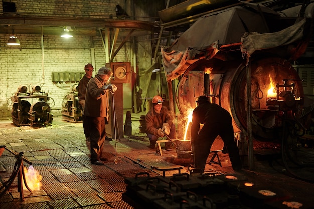 Manual worker melting metal in a furnace for future metal details in the plant