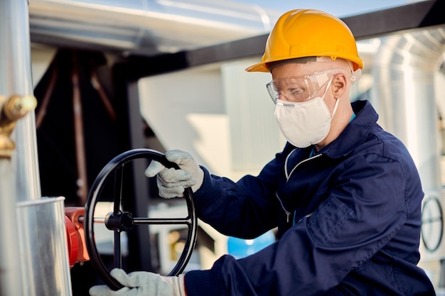 Manual worker with protective face mask closing valve at construction site