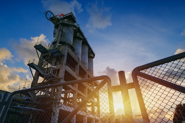 Manufacturing of petrochemical industrial plant with storage silo on sunset