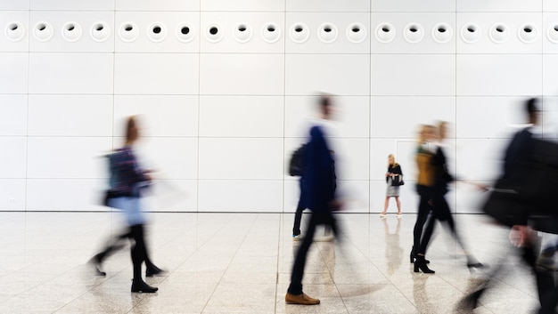 Many anonymous blurred business people traveling in the airport or at a trade fair